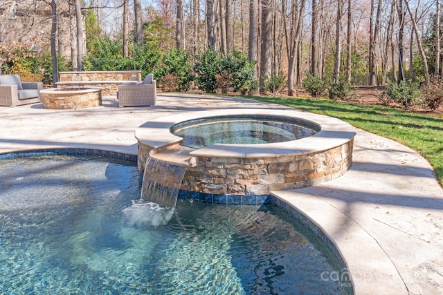 view of swimming pool featuring an outdoor fire pit, a pool with connected hot tub, and a patio