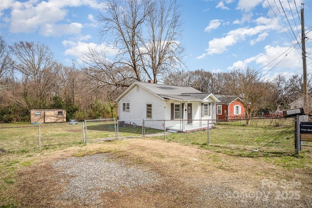 view of front of house with driveway, a fenced front yard, a gate, and a front yard