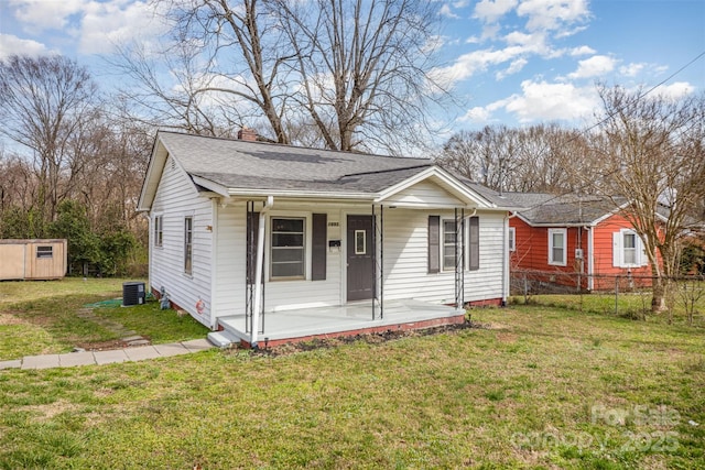 bungalow-style home featuring a chimney, a porch, a front yard, central AC, and fence