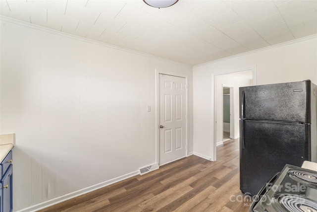 kitchen featuring visible vents, electric stove, wood finished floors, freestanding refrigerator, and blue cabinetry