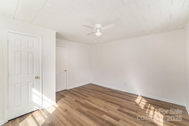 unfurnished room with ornamental molding, ceiling fan, baseboards, and wood finished floors