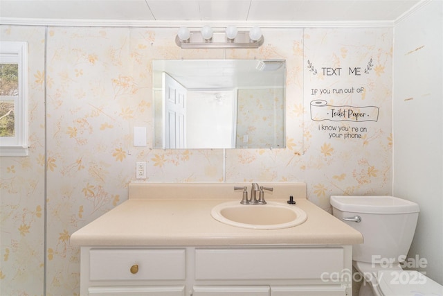 bathroom with toilet, wallpapered walls, and vanity