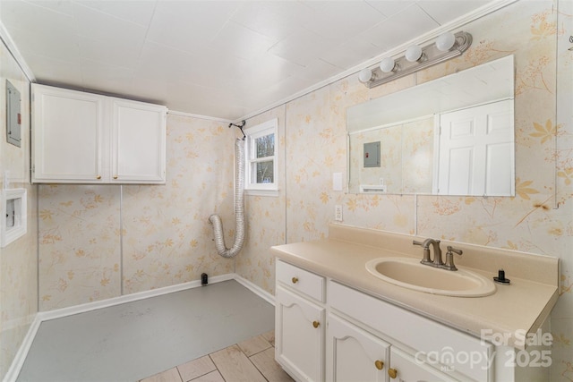 bathroom featuring baseboards, vanity, and wallpapered walls