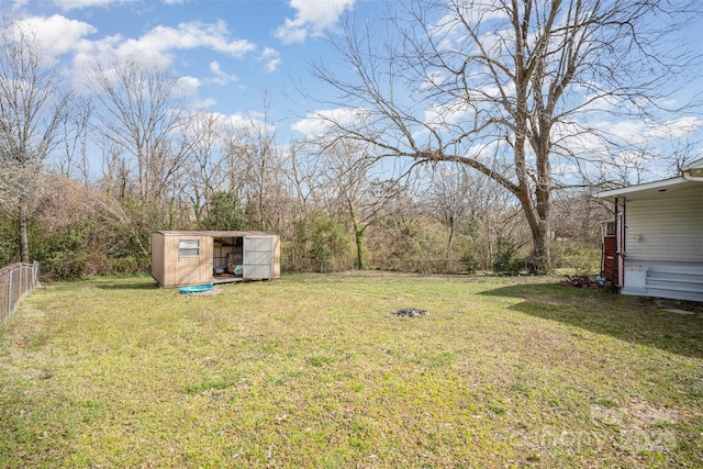 view of yard featuring fence, an outdoor structure, and a shed