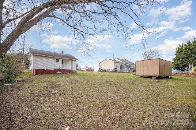 view of yard with a storage unit, an outdoor structure, and fence