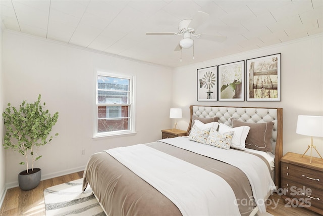 bedroom featuring baseboards, ceiling fan, wood finished floors, and crown molding