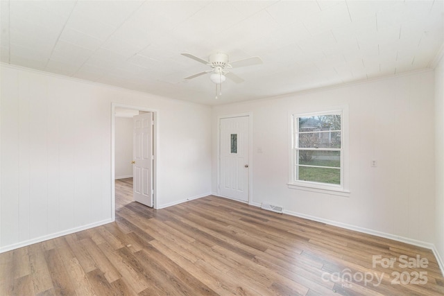 unfurnished room with light wood finished floors, baseboards, visible vents, and a ceiling fan