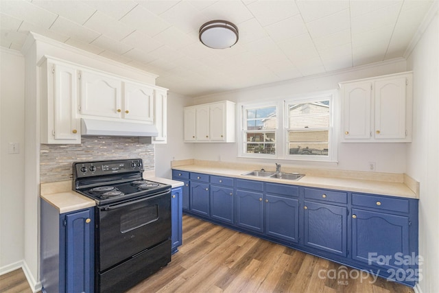 kitchen featuring white cabinets, black range with electric stovetop, blue cabinetry, under cabinet range hood, and a sink