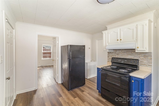 kitchen with light countertops, white cabinets, blue cabinets, under cabinet range hood, and black appliances