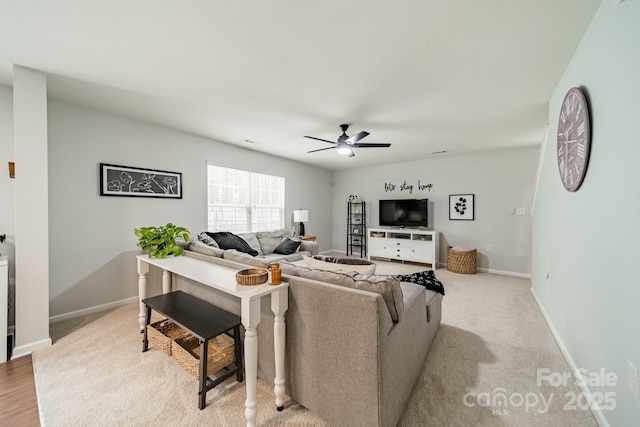 living area featuring ceiling fan and baseboards