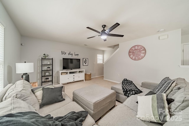 living room featuring carpet floors, baseboards, and a ceiling fan