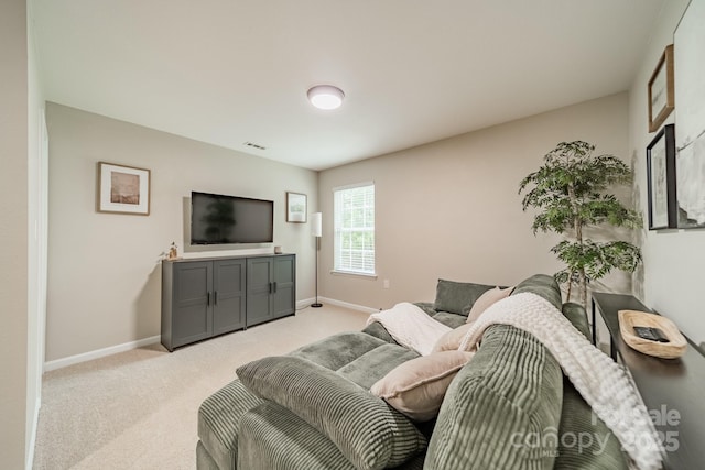 living area with baseboards, visible vents, and light colored carpet