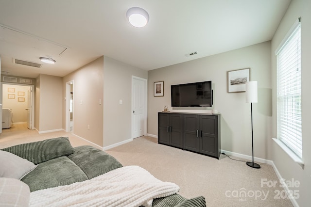 living room featuring light carpet, baseboards, visible vents, and attic access