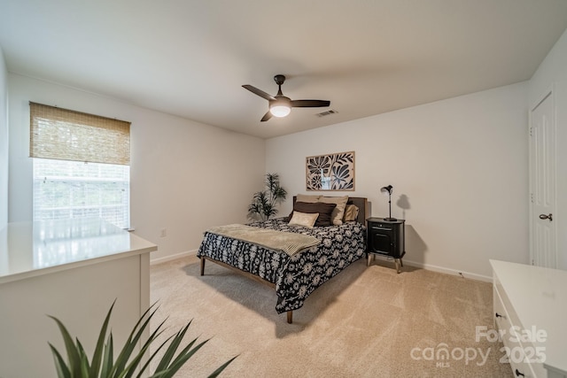 bedroom featuring visible vents, light carpet, and baseboards