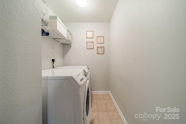 clothes washing area featuring washing machine and dryer, laundry area, and baseboards