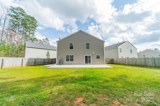 rear view of property featuring a patio area, a yard, and a fenced backyard