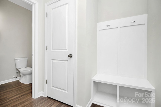 mudroom featuring dark wood-type flooring and baseboards