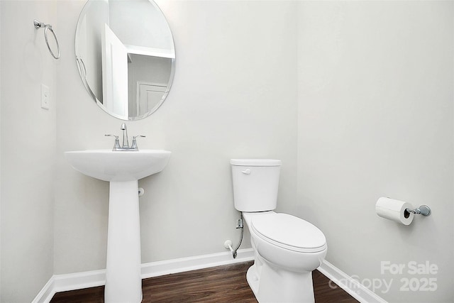 bathroom featuring baseboards, toilet, and wood finished floors