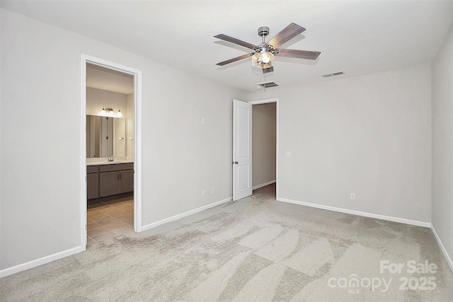 unfurnished bedroom featuring light carpet, connected bathroom, visible vents, and baseboards