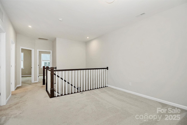 carpeted empty room with recessed lighting, visible vents, and baseboards