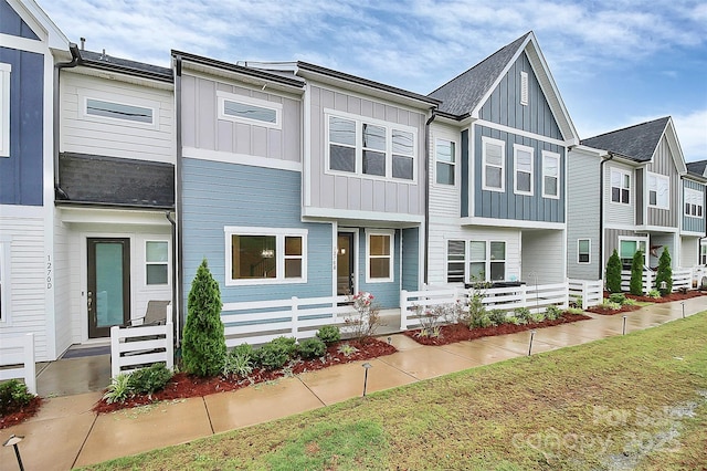 view of property featuring board and batten siding and fence