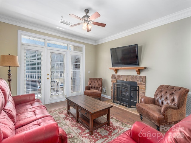 living room with ornamental molding, a fireplace, and wood finished floors