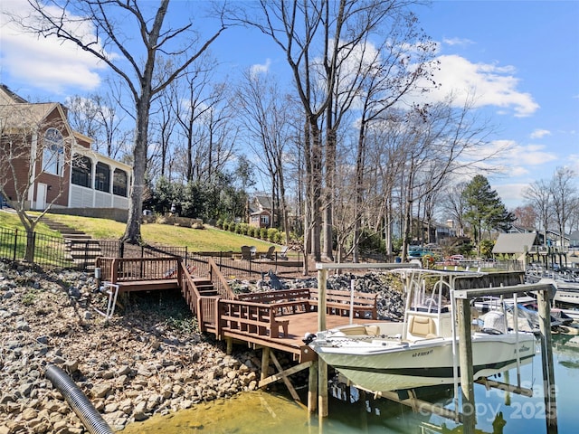 view of dock featuring a yard, a water view, and boat lift