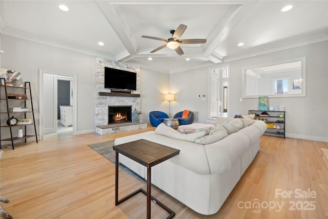 living area with light wood-style flooring, ornamental molding, recessed lighting, a fireplace, and baseboards