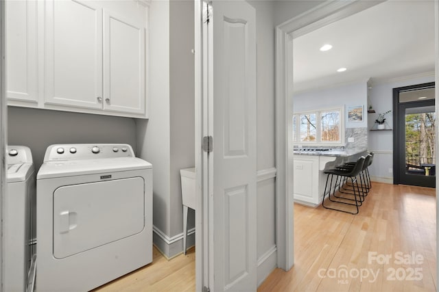 laundry room with light wood finished floors, recessed lighting, cabinet space, ornamental molding, and independent washer and dryer