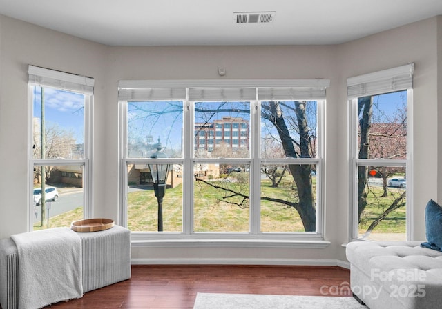 doorway featuring visible vents, baseboards, and wood finished floors