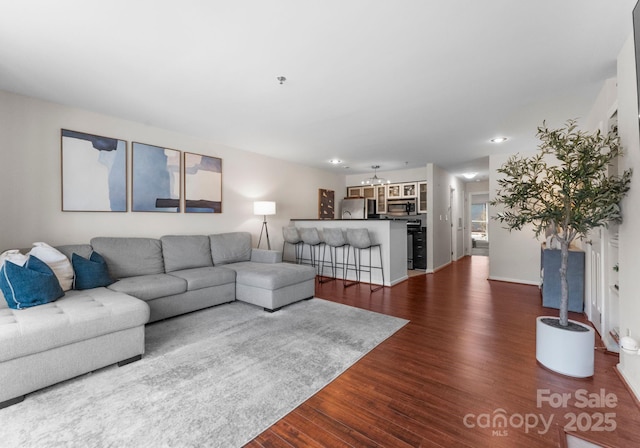 living room with dark wood-type flooring and baseboards