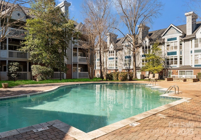 community pool featuring a residential view and a patio area