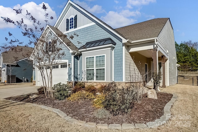 exterior space featuring roof with shingles, concrete driveway, a standing seam roof, metal roof, and stone siding