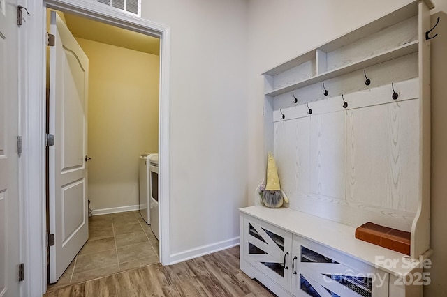 mudroom with light wood-style floors, visible vents, baseboards, and independent washer and dryer