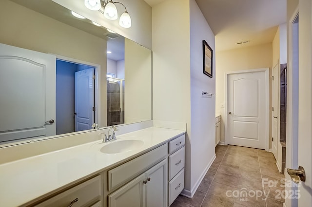 bathroom with visible vents, a tile shower, vanity, and tile patterned floors