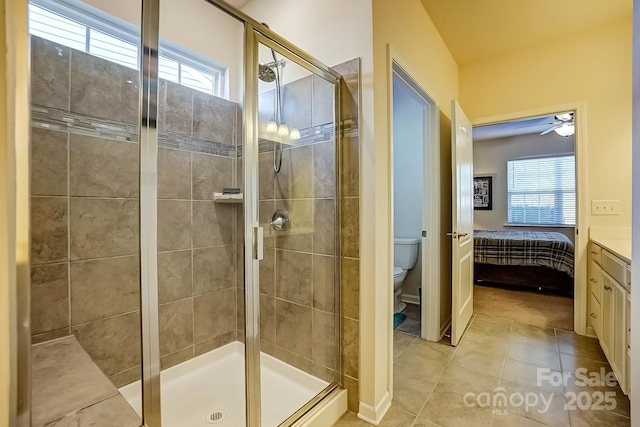 ensuite bathroom featuring a stall shower, tile patterned flooring, toilet, and ensuite bathroom