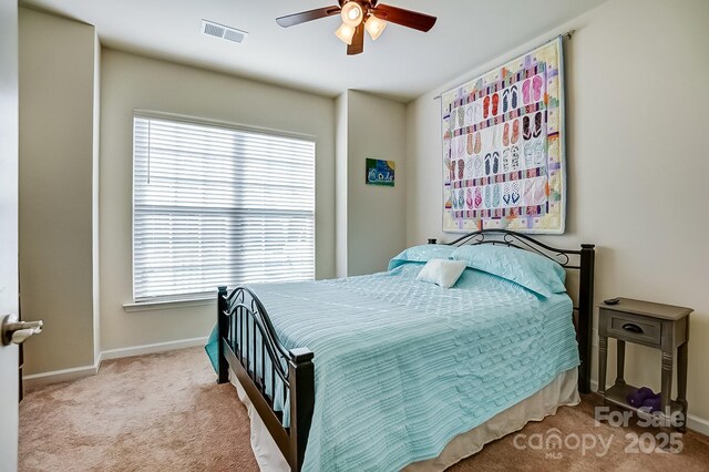 carpeted bedroom with ceiling fan, visible vents, and baseboards