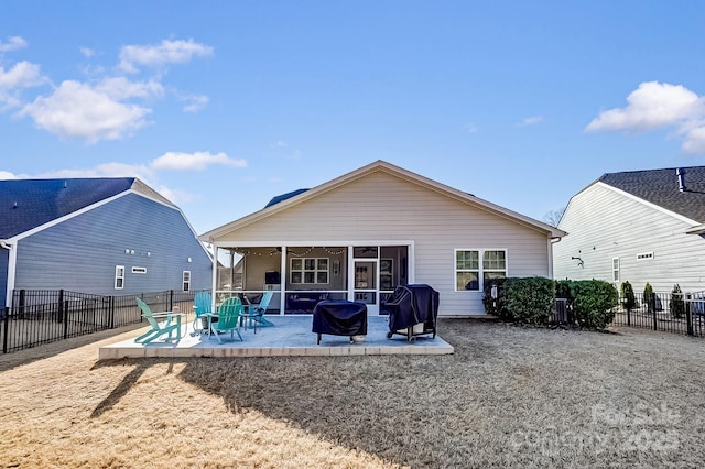 back of property with a patio, a fenced backyard, and a sunroom