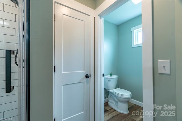 bathroom featuring wood finished floors, toilet, and baseboards