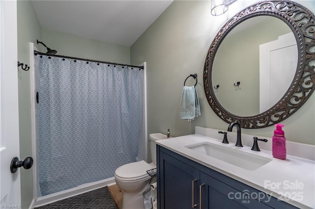 bathroom featuring curtained shower, vanity, and toilet