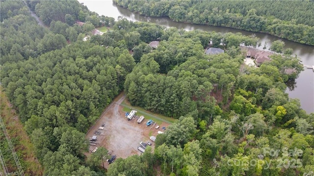 aerial view with a water view and a wooded view