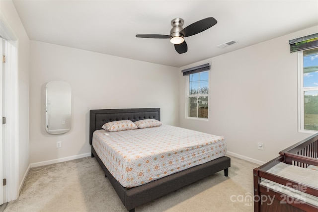 bedroom featuring baseboards, ceiling fan, visible vents, and light colored carpet