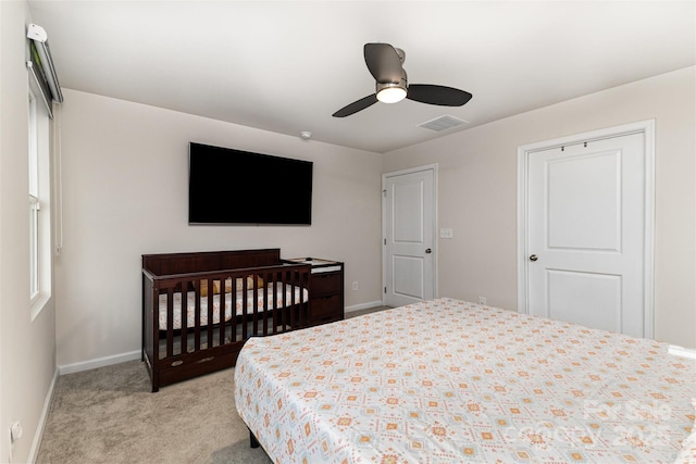 bedroom featuring light colored carpet, visible vents, ceiling fan, and baseboards