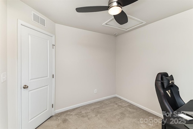 unfurnished office featuring light carpet, visible vents, baseboards, a ceiling fan, and attic access