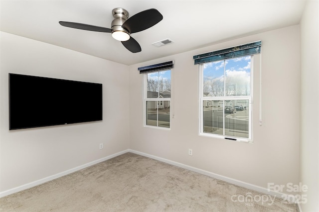 spare room featuring a ceiling fan, carpet, visible vents, and baseboards