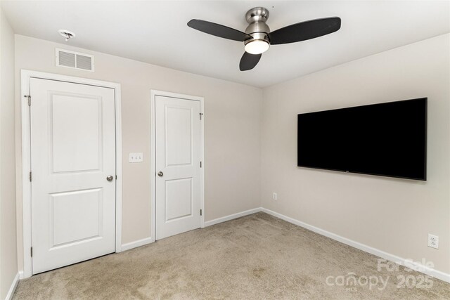 unfurnished bedroom with a ceiling fan, carpet, visible vents, and baseboards