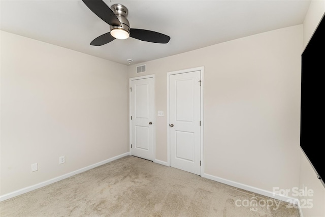 unfurnished bedroom featuring carpet floors, visible vents, ceiling fan, and baseboards