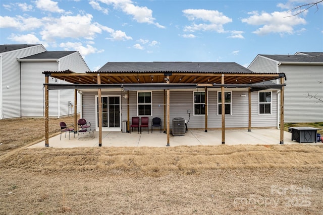 rear view of property featuring metal roof, central AC, a patio, and a pergola