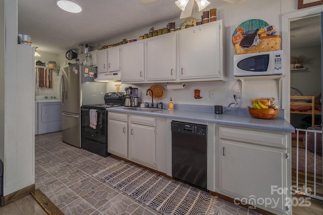 kitchen featuring white cabinets, washer / clothes dryer, under cabinet range hood, black appliances, and a sink