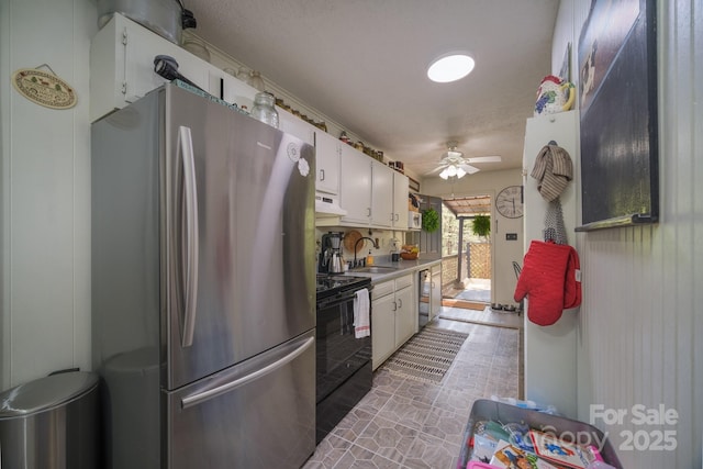 kitchen with freestanding refrigerator, black electric range, under cabinet range hood, white cabinetry, and a sink